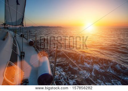 Luxery sailing yacht glides through the waves during a wonderful sunset.