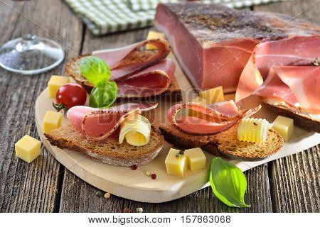 South Tyrolean bacon snack with fresh stone oven baked bread and mountain cheese cubes