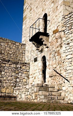 Stone medieval tower with portal and balcony