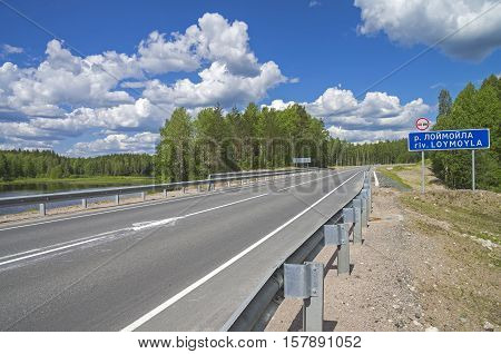 A road sign with the name of the Loymoyla river on a bridge on the federal highway A121. Sunny day in June. South Karelia Russia.
