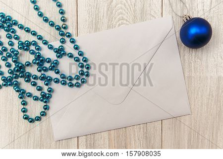 Christmas mokup with empty envelope blue bead and balls. New Year.Wooden table