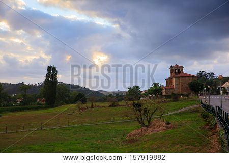 Cow grazing in the countryside. Church of Nuestra Snora de Septiembre in the background Arce. Spain