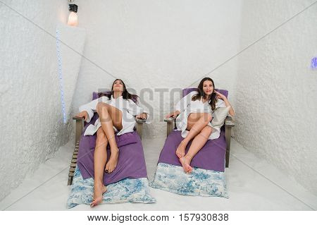Two happy women relaxing in a SPA Salarium salt cave.
