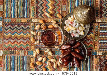 sweets, dates and tea on a traditional Arabian carpet