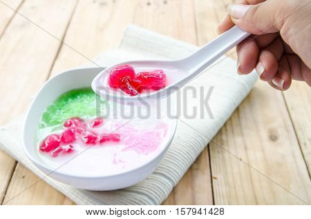 Tub Tim Krob ,Stuffed Water Chestnut in Syrup and Coconut Milk on wood table thailand dessert.