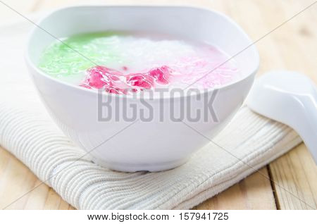 Tub Tim Krob ,Stuffed Water Chestnut in Syrup and Coconut Milk on wood table thailand dessert.