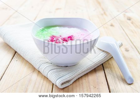 Tub Tim Krob ,Stuffed Water Chestnut in Syrup and Coconut Milk on wood table thailand dessert.
