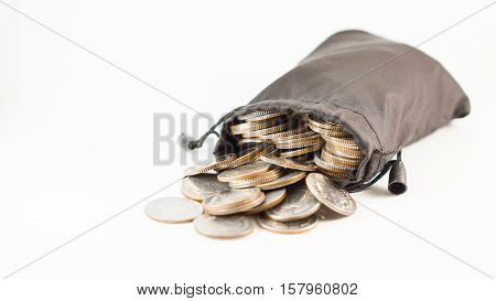 Financial saving and background concept - close up thai baht coins in black bag overflow with copyspace