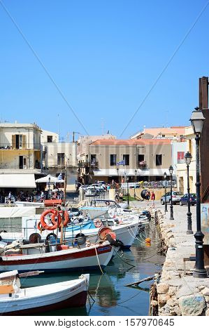 RETHYMNO, CRETE - SEPTEMBER 15, 2016 - View of traditional fishing boats in the inner harbour with waterfront restaurants to the rear Rethymno Crete Greece Europe, September 15, 2016.