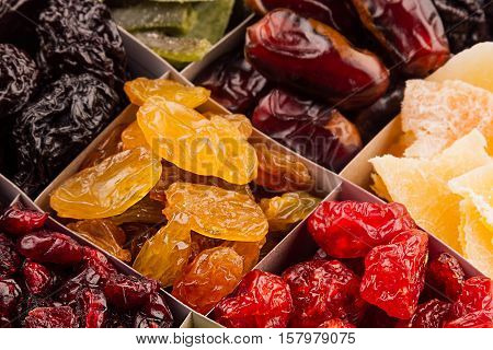 Assortment of dried fruits closeup background in square cells. Decorative pattern of dry exotic fruit. Top view.