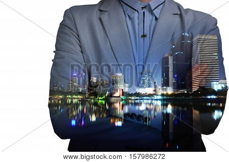 Young man in suit and with folded arms on abstract illuminated night city background. Double exposure