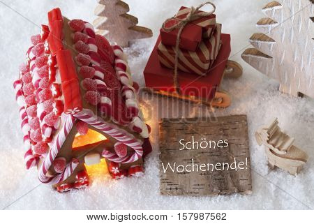 Label With German Text Frohe Weihnachten Means Merry Christmas. Gingerbread House On Snow With Christmas Decoration Like Trees And Moose. Sleigh With Christmas Gifts Or Presents.