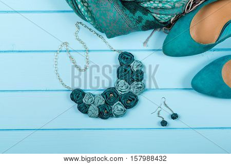 Set of fashionable women's acsessories on the blue wooden background.