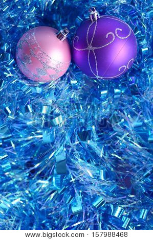 Photo by violet and pink christmas balls with ornament on the blue tinsel.