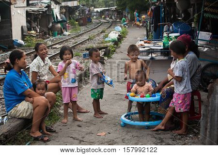 Bangkok , Thailand - july 26, 2005: 
A mother and her children living along the railroad tracks. There are an estimated 7.3 million people that are considered to be in poverty in Bangkok, Thailand.