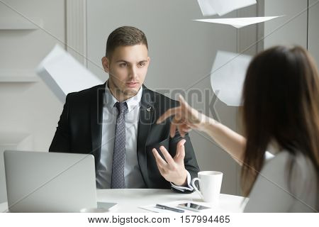 Two business people at a heated dispute or argument, the process of negotiation breaks down, misunderstanding, agreement cannot be reached. Woman is throwing papers. Business concept photo
