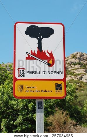MAJORCA, SPAIN - SEPTEMBER 5, 2017: A Government sign warning of the risk of fire by the Tramuntana mountains at Puerto Pollensa. The sign marks the start of the Boquer valley walking trail.