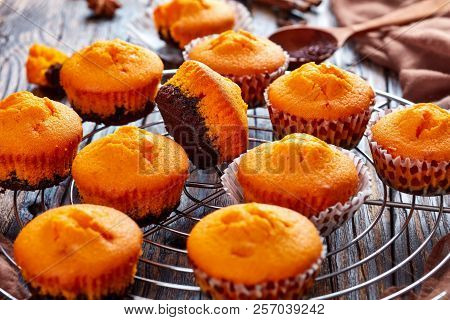 Freshly Baked Delicious Sweet Pumpkin Muffins  On A Round Stainless Steel Cake Cooling Rack On A Rus