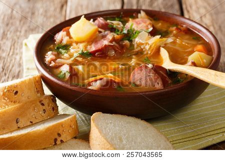Czech Food: Zelnacka Cabbage Soup With Sausages And Vegetables Close-up In A Bowl. Horizontal
