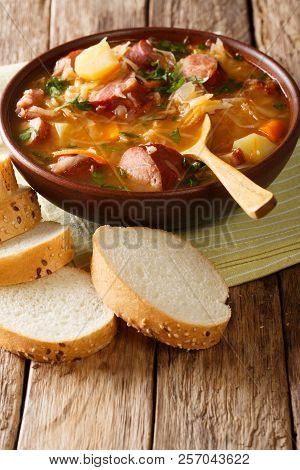 Traditional Czech Soup Zelnacka Of Sauerkraut With Sausages And Vegetables Close-up In A Bowl. Verti