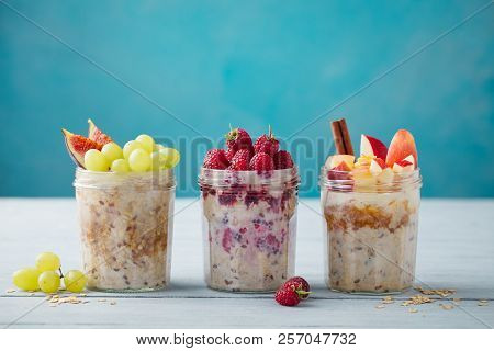 Overnight Oats, Bircher Muesli With Fresh Berries And Fruits In A Glass Jars On Wooden Table Backgro