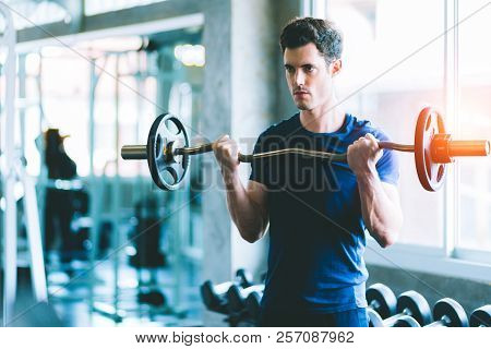Fit Caucasian Handsome Young Man And Big Muscle In Sportswear. Young Man Holding Dumbbell During An 