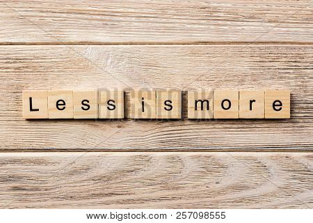 Less Is More Word Written On Wood Block. Less Is More Text On Table, Concept.