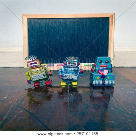 robot and a  blacboard on a wooden floor  with reflection 