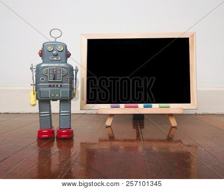robot and a  blacboard on a wooden floor  with reflection 