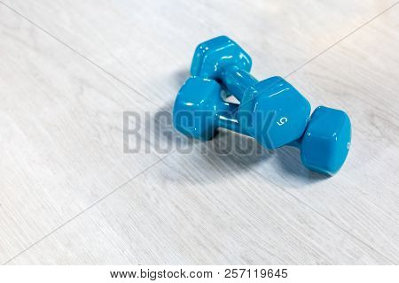 Blue Modern Dumbbells On A Wooden Floor