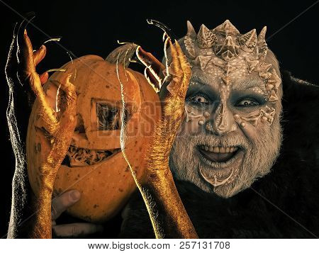 Halloween Man With Dragon Skin Smiling With Pumpkin. Zombie Hands With Black Nails Grabbing Jack O L
