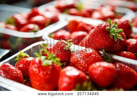 Close Up Of Fresh Red Ripe Strawberries In Transparent Plastic Container Boxes On Retail Market Disp