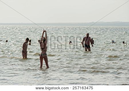 Sennoy, Russia - July 18, 2017: Taman Gulf. Silhouettes Of Group Of People Swimming In Sea
