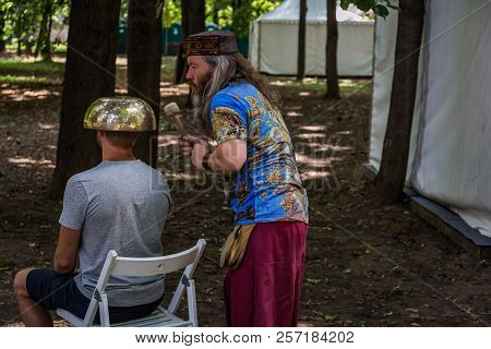 Moscow, Park On Krasnaya Presnya, August 05, 2018: A Man Makes A Massage With A Large Tibetan Singin