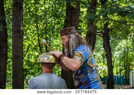Moscow, Park On Krasnaya Presnya, August 05, 2018: A Man Makes A Massage With A Large Tibetan Singin