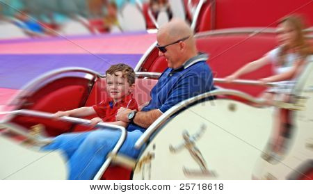Padre y los niños que se divierten en el Parque de atracciones de spinning