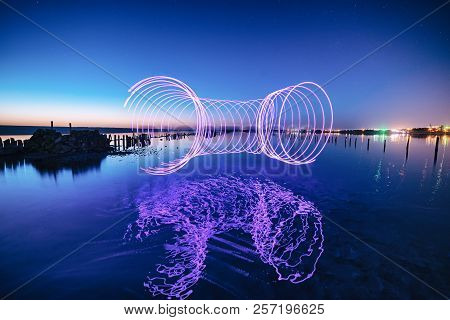 Amazing Laser Fireshow Performance In The Night Blue Sky With Reflections In The Sea Water
