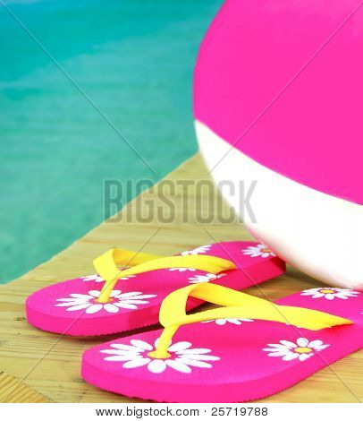 Pembe ve beyaz beachball rıhtım üzerinde oldukça flip flop ile