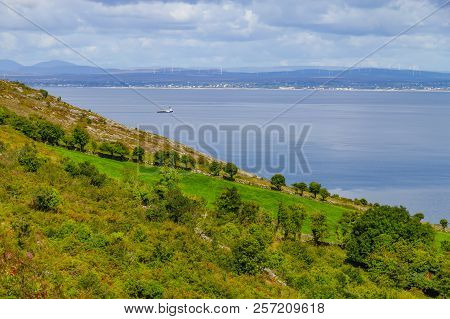 Farms In Burren Way Trail With Galway Bay And Boat In Background