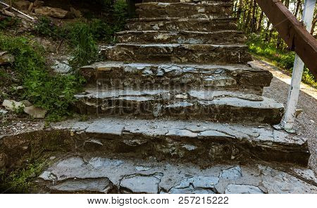 An Old Open Outer Stone Staircase. Stone, Cement Steps Of The Old Staircase With Traces Of Weatherin