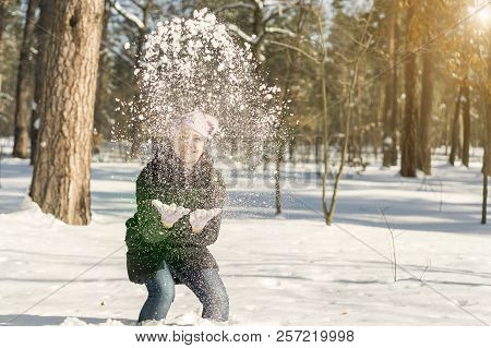 Portrait Of The Beautiful Girl Throwing Snow In The Winter. Happy Young Woman Plays With A Snow In S