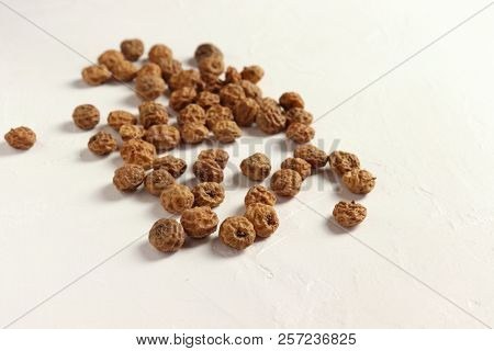 Isolated Tigernuts / Earth Almonds / Nutsedges On Slightly Structured White Surface