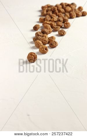Isolated Tigernuts / Earth Almonds / Nutsedges On Slightly Structured White Surface, Copy Space
