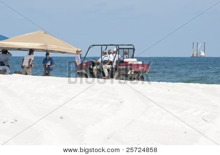 ORANGE BEACH, AL - 10 de junho: Petróleo derramamento de trabalhadores tentam limpar o óleo ao longo da praia em um turista 