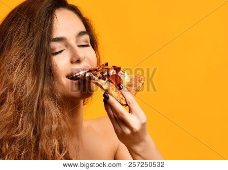 Young Beautiful Woman Eat Slice Of Pepperoni Pizza With Closed Eyes Smiling On Yellow Background