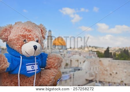 Teddy Bear On A Sunny Day On The Background Of The Golden Dome And The Wailing Wall In Jerusalem. To