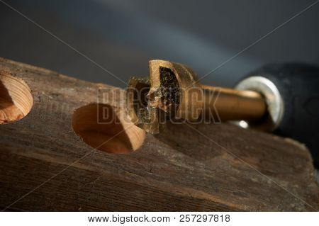 Close Up Forstner Bit For Drilling Circular Holes With A Portable Drill Sitting On Top Of Wooden Blo