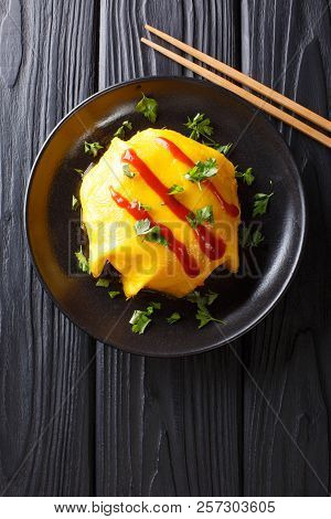 Delicious Omurice Omelette Stuffed With Rice, Chicken And Vegetables Served On A Plate. Vertical Top