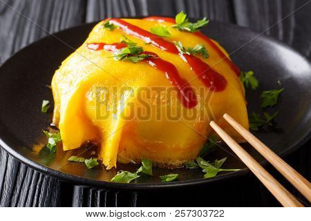 Japanese Traditional Food: Omurice Omelette With Rice, Chicken, Vegetables And Tomato Sauce On A Bla