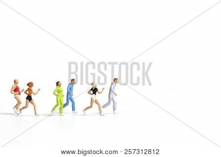 Miniature People Running On White Background , Healthy Lifestyle And Sport Concepts.